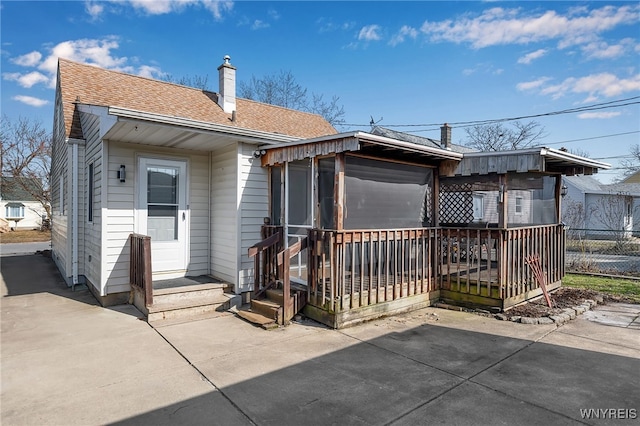 rear view of property featuring a patio area, fence, roof with shingles, and a chimney