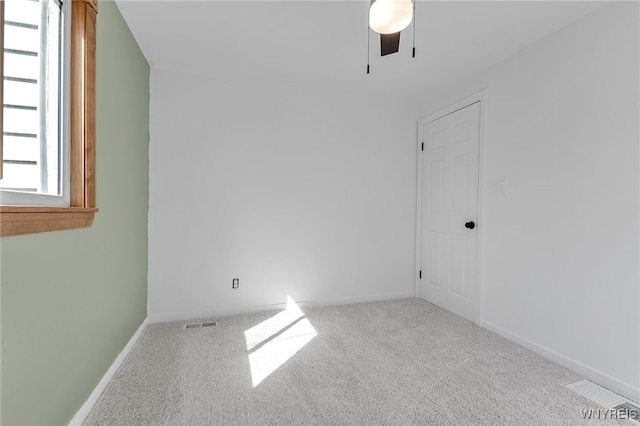 spare room with carpet flooring, visible vents, baseboards, and ceiling fan