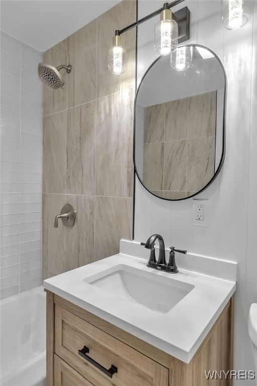 bathroom with toilet, tile walls, shower / washtub combination, and vanity