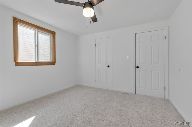 unfurnished bedroom with visible vents, carpet, baseboards, and ceiling fan