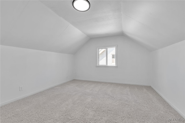 additional living space featuring baseboards, carpet floors, and vaulted ceiling