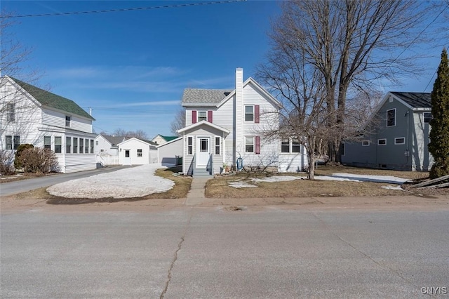 view of front of home with entry steps, driveway, and a chimney