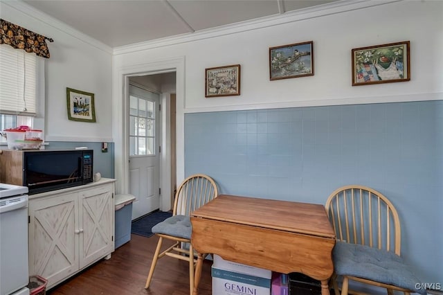 dining space featuring crown molding, tile walls, and dark wood-style flooring