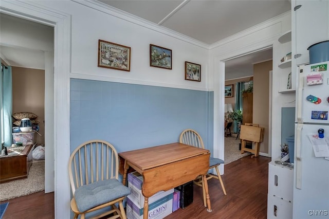 dining area featuring wood finished floors and ornamental molding