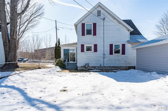 snow covered rear of property with fence