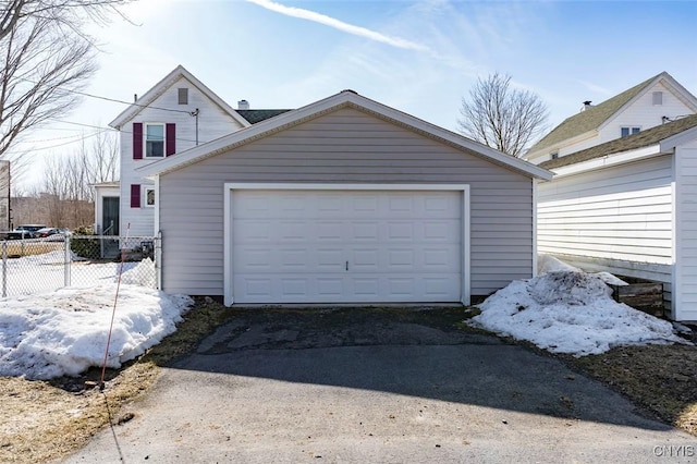 detached garage featuring fence and driveway