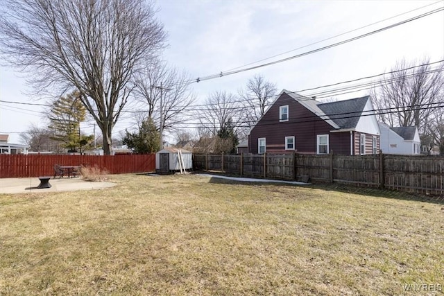 view of yard featuring an outdoor structure, a fenced backyard, a shed, and a patio