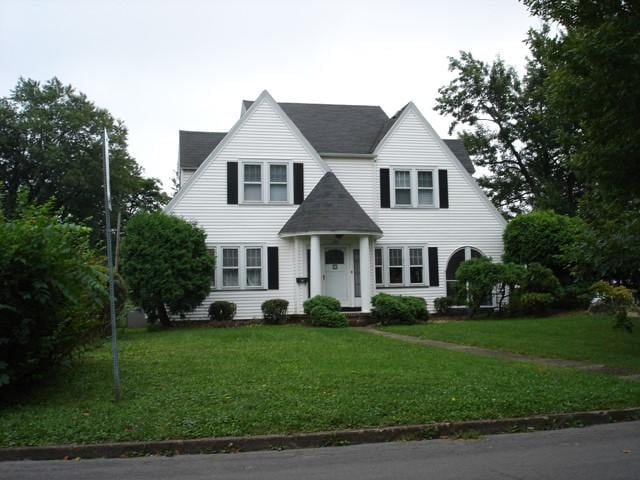 view of front of home featuring a front lawn and roof with shingles