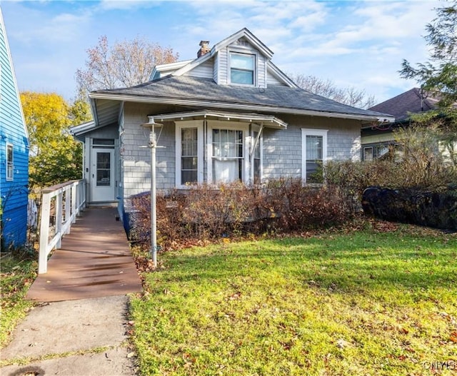 bungalow featuring a front lawn and a chimney