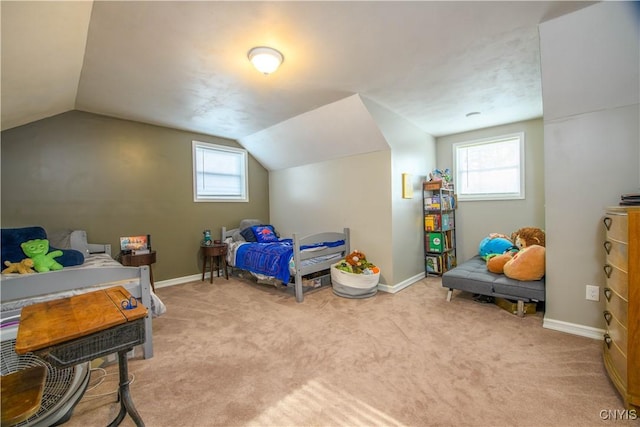 bedroom with multiple windows, light colored carpet, and vaulted ceiling