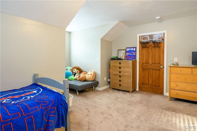 carpeted bedroom featuring baseboards and vaulted ceiling