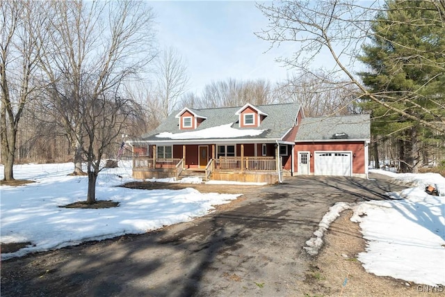 view of front of home with driveway, covered porch, and an attached garage