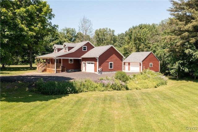 view of front of house with a front yard, a garage, and covered porch