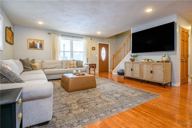 living room with stairs, recessed lighting, wood finished floors, and baseboards