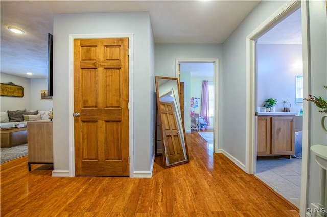 corridor featuring wood finished floors and baseboards