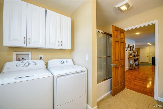 laundry room with light tile patterned floors, baseboards, visible vents, separate washer and dryer, and cabinet space