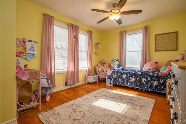 bedroom with ceiling fan, baseboards, and wood finished floors