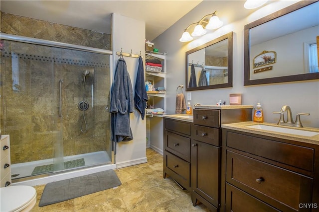 full bathroom with a sink, double vanity, and a shower stall