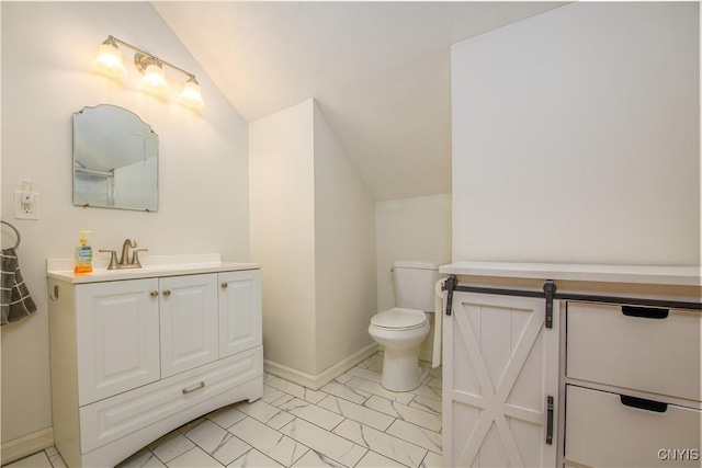 bathroom featuring baseboards, toilet, lofted ceiling, marble finish floor, and vanity