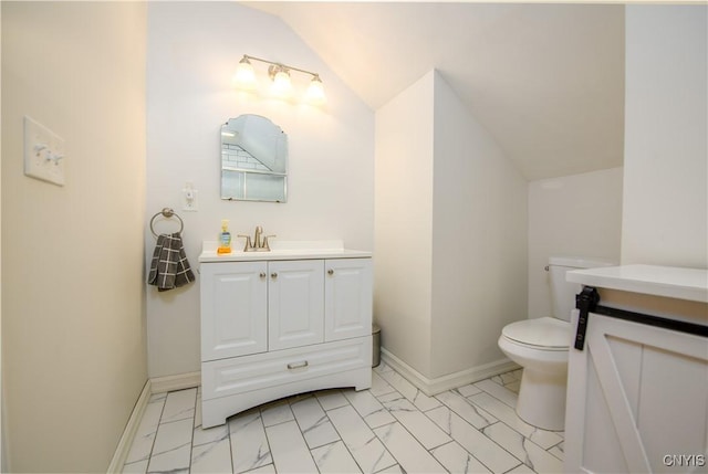 half bathroom with vanity, lofted ceiling, toilet, and marble finish floor