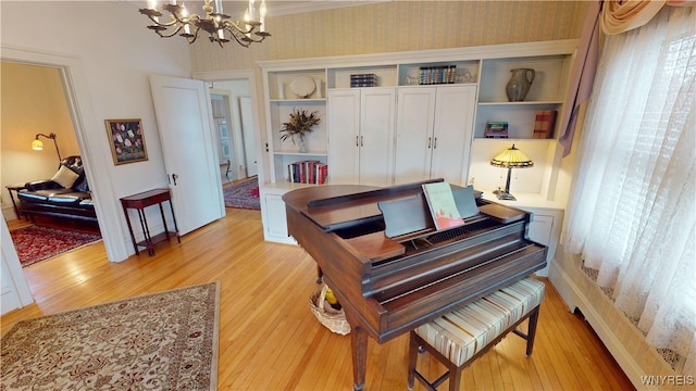 office space with wallpapered walls, light wood-style flooring, a notable chandelier, and baseboards