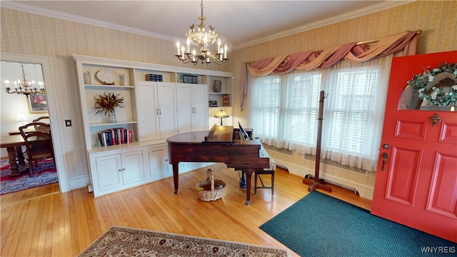 home office featuring wallpapered walls, an inviting chandelier, light wood-style flooring, and ornamental molding