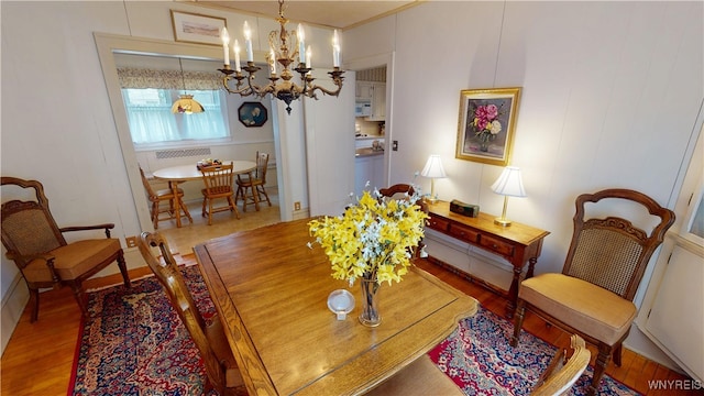 dining area with a notable chandelier and wood finished floors