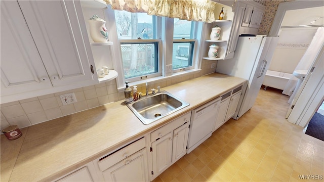 kitchen with white appliances, open shelves, a sink, light countertops, and tasteful backsplash