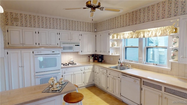 kitchen with white appliances, open shelves, a sink, light countertops, and white cabinetry