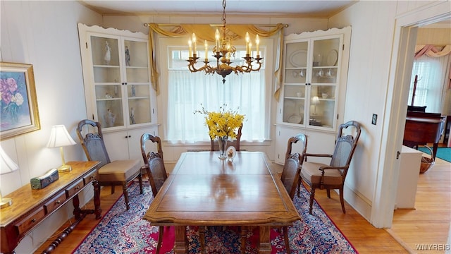 dining space with a notable chandelier and wood finished floors