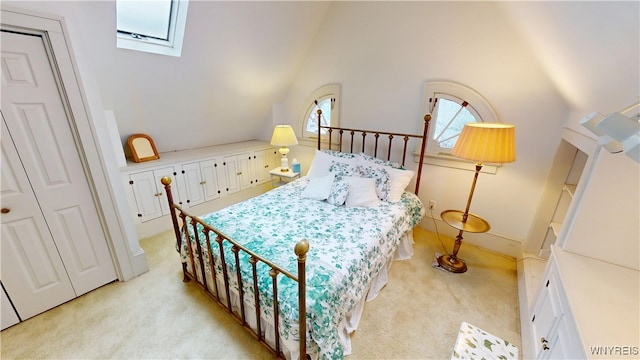 bedroom featuring high vaulted ceiling, light colored carpet, and a skylight