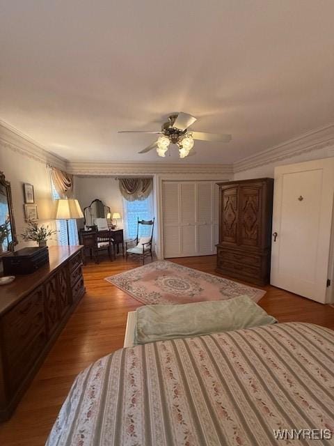 bedroom with wood finished floors, a ceiling fan, and ornamental molding