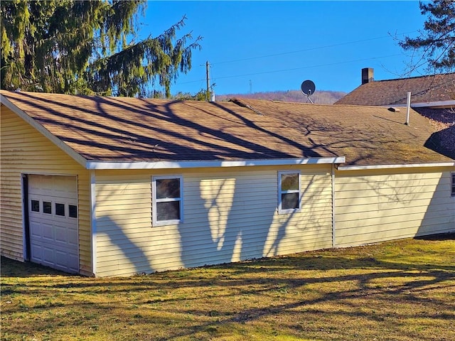 view of side of home featuring a yard and a garage