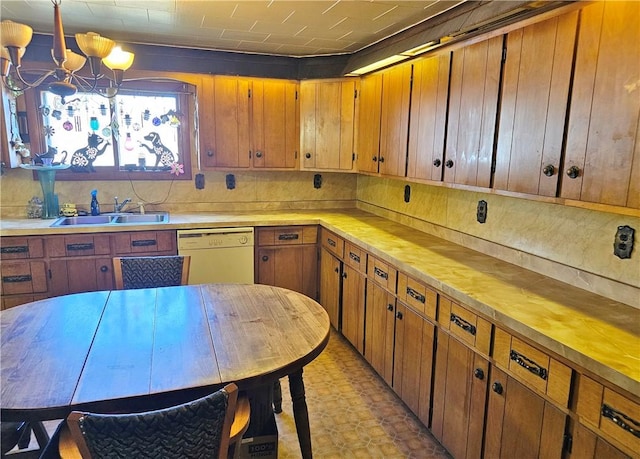 kitchen with backsplash, brown cabinets, an inviting chandelier, white dishwasher, and a sink