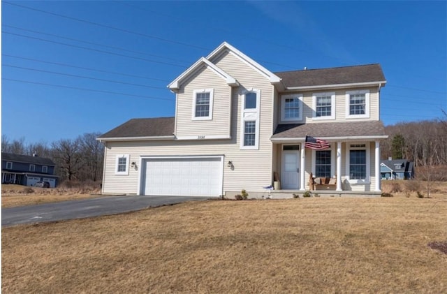 traditional-style home with aphalt driveway, covered porch, an attached garage, and a front lawn