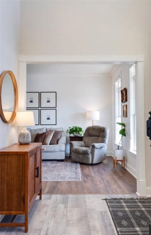 living room with crown molding, wood finished floors, and baseboards