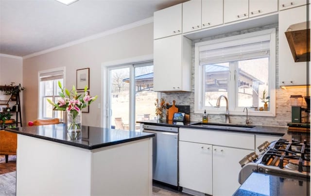 kitchen featuring a sink, dark countertops, dishwasher, and crown molding