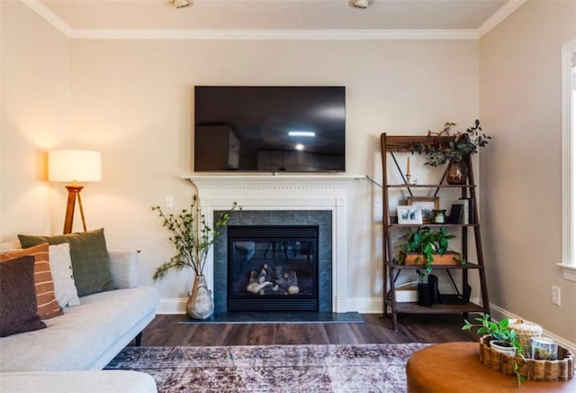 living room with a glass covered fireplace, crown molding, baseboards, and wood finished floors