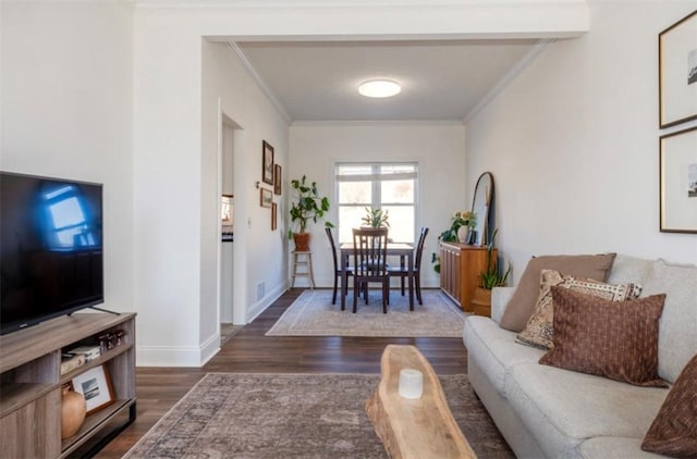 living room featuring ornamental molding, baseboards, and wood finished floors