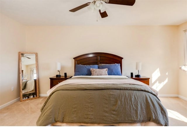 bedroom with baseboards, light carpet, and a ceiling fan