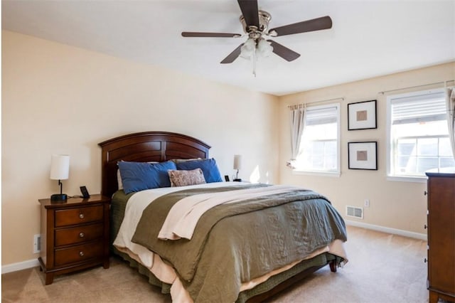 bedroom with light carpet, visible vents, ceiling fan, and baseboards