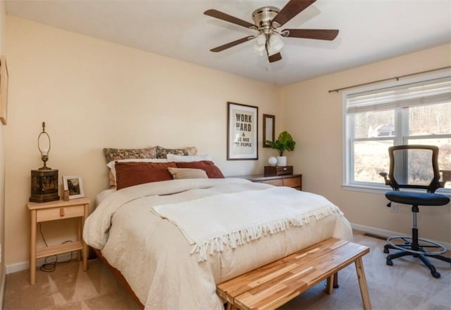 bedroom featuring light carpet, ceiling fan, and baseboards