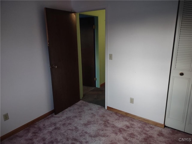 unfurnished bedroom featuring a closet, baseboards, and carpet floors