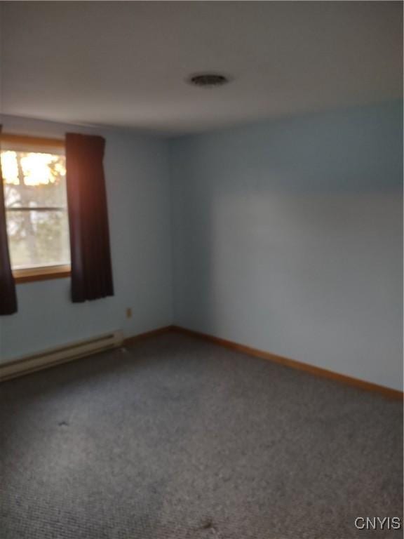 carpeted empty room with baseboard heating and baseboards