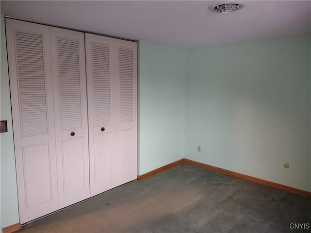 unfurnished bedroom featuring visible vents, baseboards, carpet, and a closet