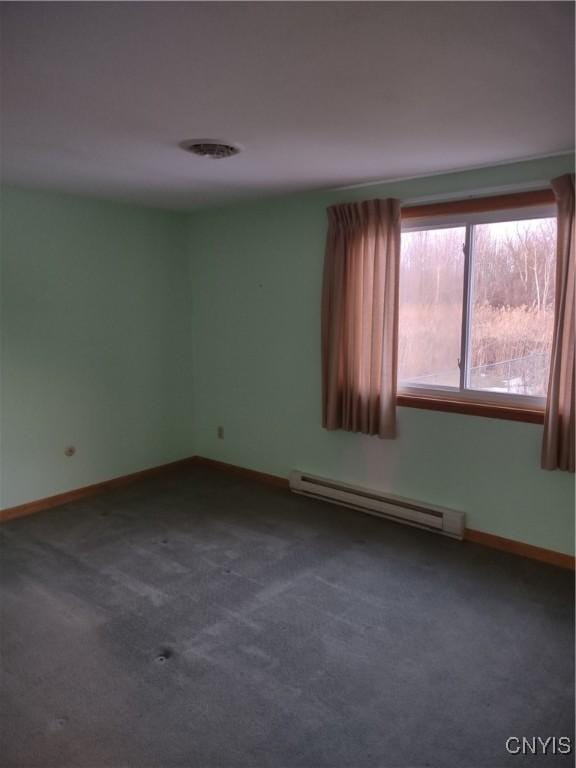 empty room with a baseboard radiator, baseboards, and dark carpet