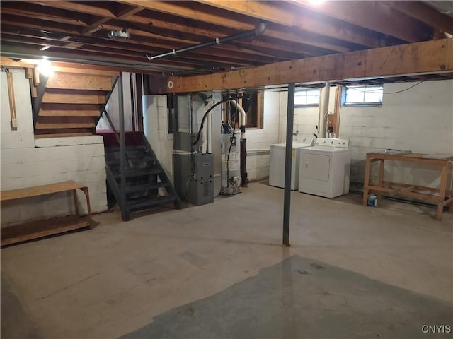 basement with stairs, heating unit, and independent washer and dryer