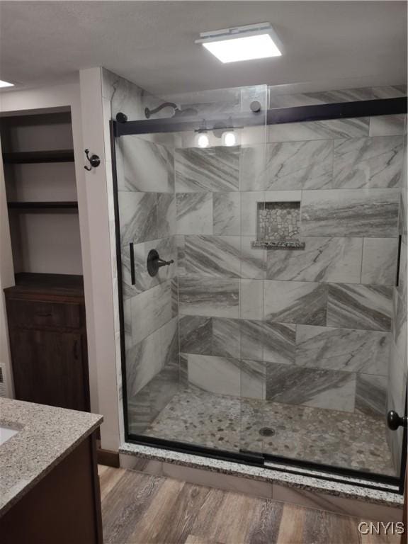 bathroom featuring a stall shower, vanity, and wood finished floors