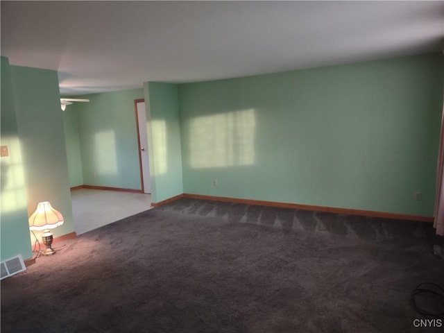 carpeted empty room featuring visible vents, baseboards, and a ceiling fan