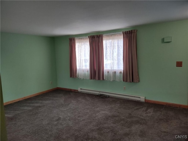 empty room featuring a baseboard heating unit, baseboards, and carpet